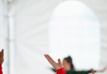 직장인과 주부에게 스트레칭이 필요한 이유 woman in red long sleeve shirt raising her hands