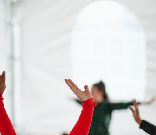 직장인과 주부에게 스트레칭이 필요한 이유 woman in red long sleeve shirt raising her hands