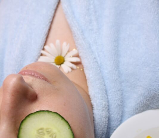 여름철 피부 진정 팩 만들기 woman wearing blue robe lying with cucumber on eye