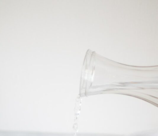 체중 감량을 위한 운동과 식사 계획: 성공적인 접근법 A person pouring water into a glass on a table