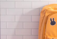 사랑의 책가방 전달식 개최 A yellow backpack sitting on top of a table