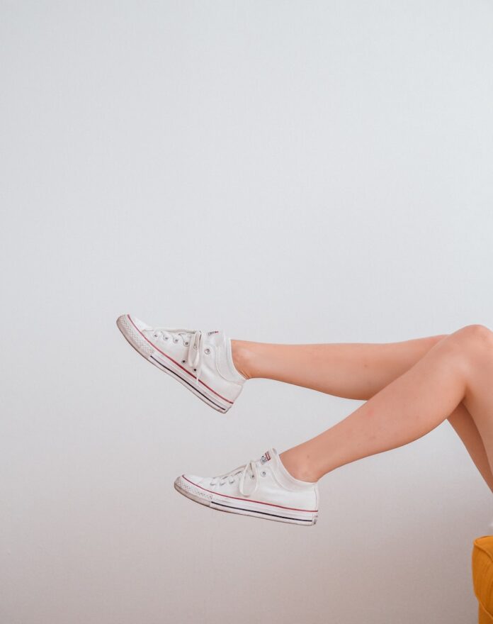 Photo by Laura Chouette woman in white low top sneakers