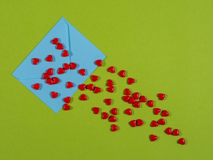 Photo by engin akyurt a blue envelope with red hearts coming out of it