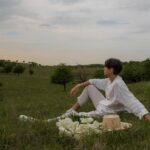 ‘만성피로’ 잡는 법, 최신 생활 트렌드가 바꾼 해법은? a man sitting on a blanket in the middle of a field