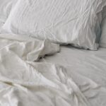 깊고 편안한 잠, 일상 속 ‘수면 루틴’이 열쇠 A rumpled white duvet and pillows on a bed.
