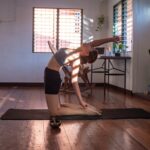 “필라테스, 바쁜 현대인의 건강 지킴이로 자리 잡다” woman in black shorts and white tank top doing yoga