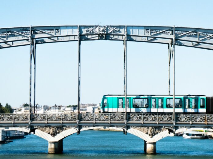 Photo by Kévin JINER a train crossing a bridge over a body of water